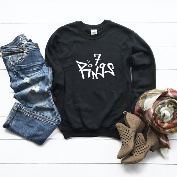 Trendy 7 Rings sweatshirt inspired by Ariana Grande's hit song. Cozy up in style and embrace the music vibes. Perfect for fans who want to make a statement with their fashion choices.