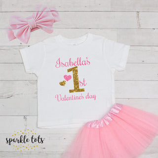 1st Valentine's Day outfit featuring a heartwarming design. Available as a standalone T-shirt or a complete set with a tutu and bow. Personalise with your baby's name for a unique touch.