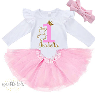 Adorable Peppa Pig 1st Birthday Outfit from Sparkle Tots – featuring a long-sleeved ruffled vest adorned with Peppa Pig charm, available with the option of a pink tutu and bow for a special celebration.