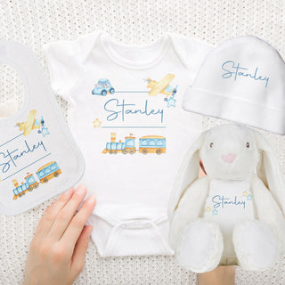 Personalised Baby Boy Gift Set featuring a baby grow, bib, hat, and a cuddly teddy bear. Each item can be personalised with the baby's name. Perfect for welcoming the new arrival with love. Choose to gift the set or individual items.