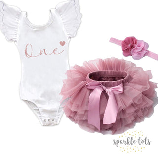 Adorable 1st Birthday Outfit in Rose Gold from Sparkle Tots – featuring an elegant leotard with frilled sleeves and pretty rose gold glitter writing, available with the option of a dusty rose tutu and bow for a special celebration.